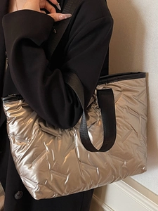 Modern silver quilted large tote bag with metallic finish and black woven straps
