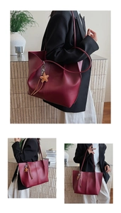 Detailed macro view of the dark burgundy tote bag featuring the star charm and leather texture