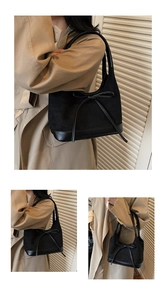 Détail d'un sac cabas en daim noir avec patchwork en cuir et décoration de nœud papillon
