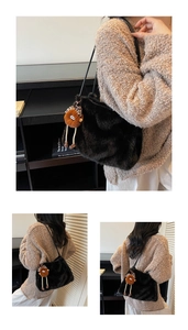 Détail d'un sac cabas en peluche noire avec breloque d'ours brun et nœud léopard