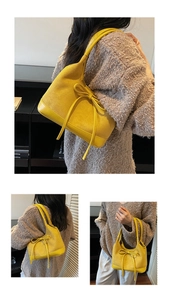 Détail du cabas en daim jaune avec nœud décoratif et base renforcée pour le trajet quotidien