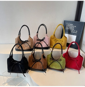 Vue détaillée de sacs cabas en daim multicolores avec nœuds sur un support d'exposition