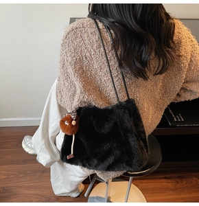 Détail du sac à bandoulière en fausse fourrure noire avec pendentif en peluche mignon