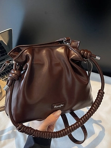 Chic dark brown pleated bucket bag with spiral handle and metallic brand plaque