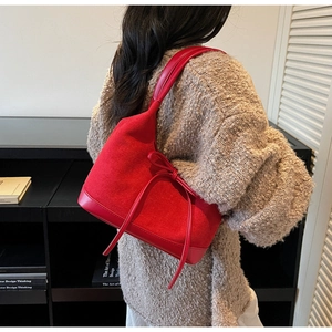 Détail du sac cabas rouge avec patchwork en daim et décoration de nœud élégante