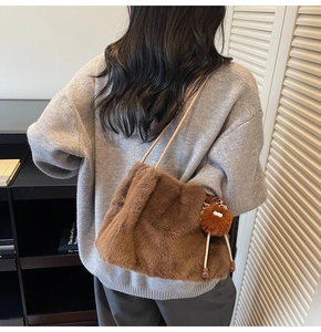Détail d'un sac cabas en peluche marron doux avec porte-clés léopard porté à l'épaule