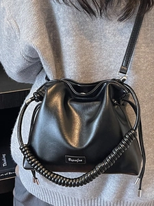 Fashionable black faux leather bucket bag with drawstring closure and spiral handle