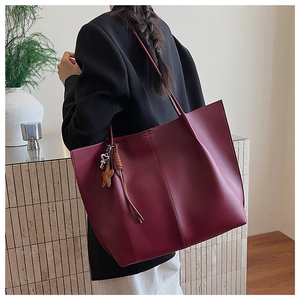 Detail view of large burgundy tote bag with center seam and star keychain pendant