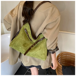 Detail of avocado green suede tote bag showing shoulder strap and gold buckle adjustment