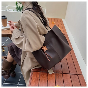 Macro shot of a deep brown minimalist tote bag featuring a decorative starfish charm detail