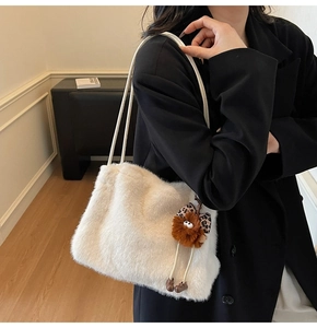 Détail du sac cabas blanc en fausse fourrure avec breloque léopard et texture douce