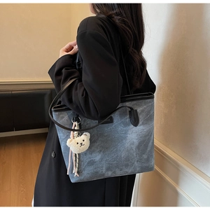 Detail of grey large tote bag with cloud pattern and white fluffy bear charm