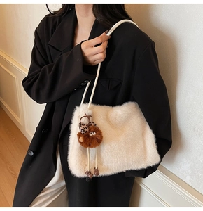 Détail d'un sac cabas en fausse fourrure crème avec texture douce et breloque peluche