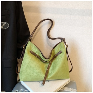 Detail of light green suede tote bag with brown leather straps and gold metal hardware