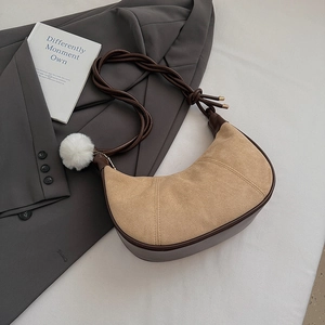 Detail of crescent bag featuring contrast suede textures and woven shoulder strap