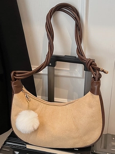 Minimalist light camel suede crescent underarm bag with brown trim and plush pompom charm