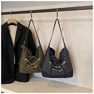 Detail of leopard print tote bags with drawstring ribbons and stylish artistic text