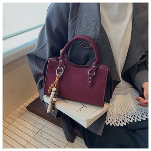 Detail of burgundy vintage mini tote bag with silver hardware and wooden bead charm