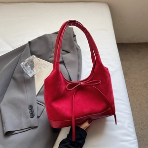 Détail du sac cabas rouge avec textures mixtes daim et cuir et nœud décoratif