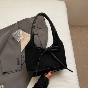 Détail du sac cabas noir avec décoration en nœud et patchwork de cuir suédé élégant
