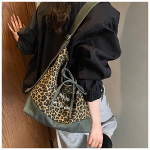 Detail view of denim leopard print tote bag with adjustable strap and drawstring closure