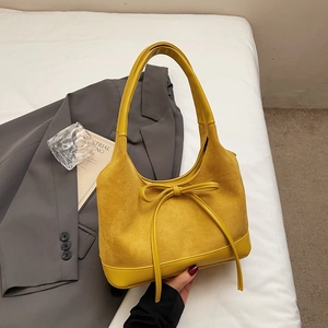 Détail du sac fourre-tout jaune en forme de croissant avec texture daim et petit noeud