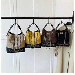 Quilted bucket bags with chain straps in multiple colors hanging on a display rack