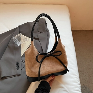 Détail du sac cabas en daim marron avec nœud en cuir noir et surpiqûres contrastées