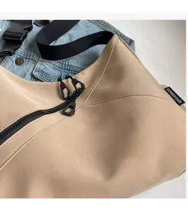 Detail shot of khaki travel tote with durable black double zippers and wide shoulder strap