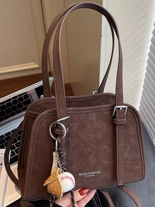 Chic dark brown faux leather shoulder bag with vintage texture and baseball charm