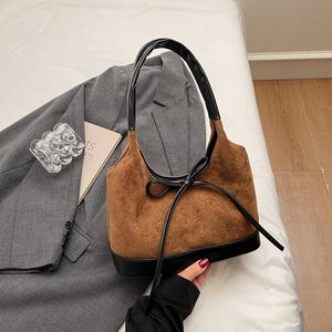 Détail de la couture en cuir noir et du daim marron vintage sur le sac fourre-tout chic