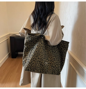 Leopard print large capacity canvas tote bag worn on shoulder by a model indoors