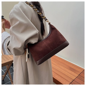 Details einer geflochtenen Kettenschultertasche aus braunem Wildleder und Leder