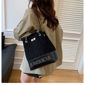 Detalle de bolso bucket acolchado negro con cadena dorada y logo de strass BOWEN NOVA
