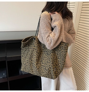 Macro shot of stylish leopard print canvas tote bag with black shoulder strap and brand label