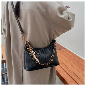Detail der gewebten schwarzen Lederschultertasche mit Goldkette und Holzperlen-Quaste