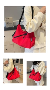 Detailed view of red canvas tote bag with wide adjustable strap and metal zipper