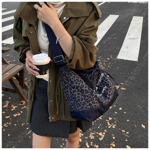 Detail of leopard print canvas bucket bag with adjustable wide strap and drawstring