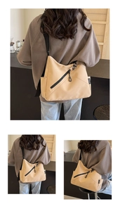 Detail view of canvas crossbody bag with diagonal zipper pocket and wide black strap