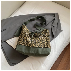Detail of leopard print canvas tote bag with olive green straps and drawstring closure