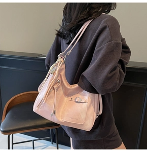 Pink faux leather hobo tote bag detail with side pocket and buckle on model