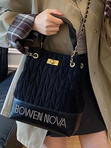 Chic black quilted chain bucket bag with Bowen Nova studs and metallic turn-lock closure