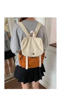 Detail of canvas backpack with cream and orange color blocking and drawstring pockets