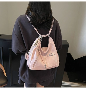 Detail view of pink pearlescent tote bag with fringe charm and silver metal hardware