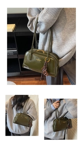 Close-up of dark green glossy leather Boston bag with gold logo and woven charm detail