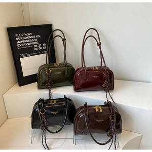 Four colors of glossy leather Boston shoulder bags displayed on tiered platforms