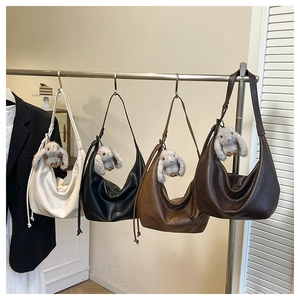 Detail view of four stylish crescent hobo bags in assorted colors with cute rabbit charms
