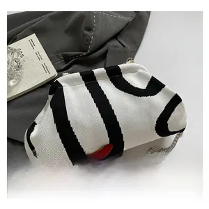 Detailed macro view of the black and white striped knitted cloud bag with a metal chain strap