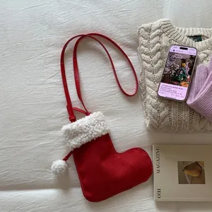Détail du sac bandoulière botte de Noël en suédine rouge avec pompon blanc et bordure fourrure