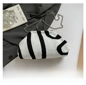 Detail view of the knit shell bag with black and white stripes and silver metal chain